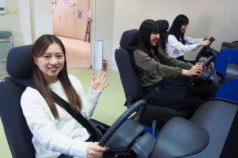 運転シュミレーションをする機械を操作する在校生の写真