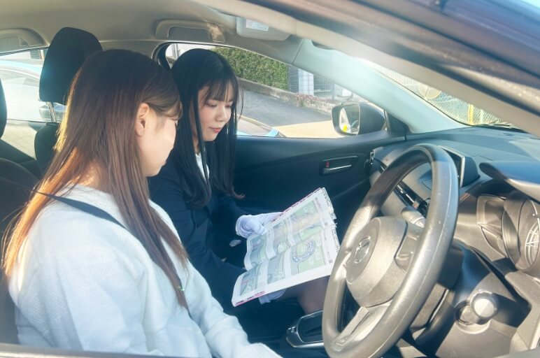 車内で在校生に指導をする講師と指導を受けている在校生の写真