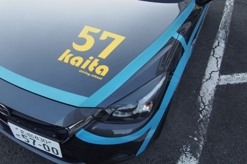 黒に青ラインの教習車に黄色で57Kaitaとプリントされている