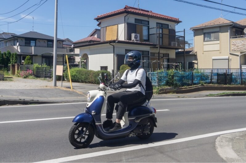 原付バイクに乗っている人の写真